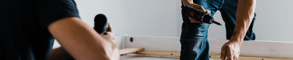 Deux employés Li.mon entrain de monter un lit au domicile du client